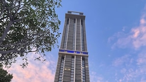 Um edifício alto e moderno com entrada destacada e fachada de vidro extensa.