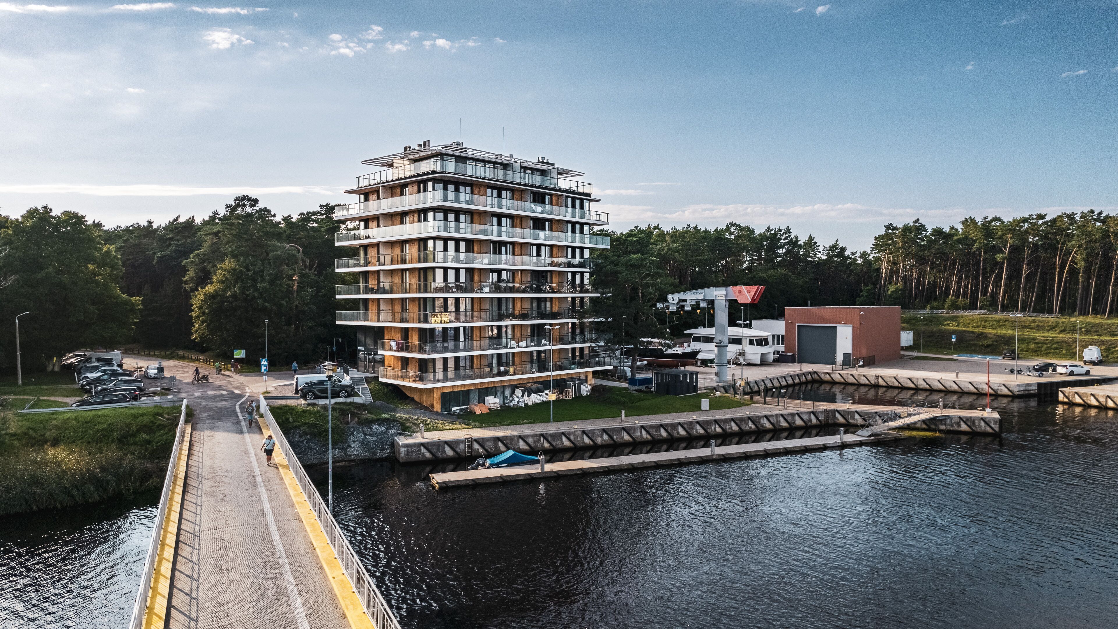 En byggnad med flera våningar, balkonger, en brygga och en vattenyta.