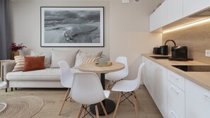 A modern kitchen with white cabinets, a wooden countertop, and a coffee machine. - Apartamenty Sun & Snow Lighthouse (Trzebiatow)