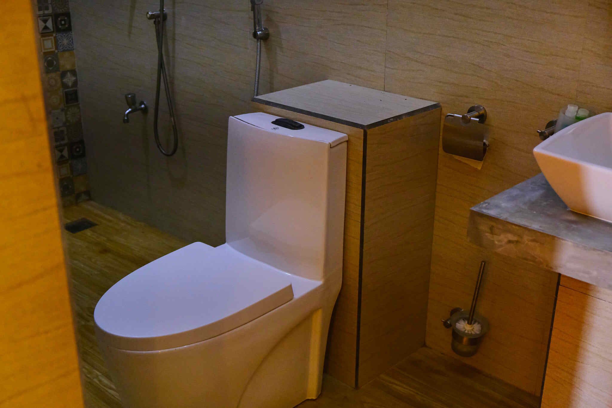 A compact bathroom with a toilet, a shower, and a sink.