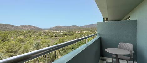 A balcony with a checkered floor, a table, and a chair.