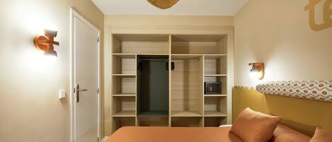A bedroom with a bed, a wardrobe, and a ceiling fan.