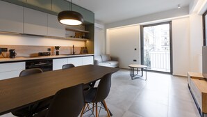 Eine moderne Küche mit Essbereich, einer Couch und einem Balkon mit Blick.