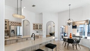A spacious kitchen with a large island, modern appliances, and a dining area with a chandelier.