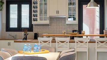 A modern kitchen with white cabinets, a central island, and pendant lighting.