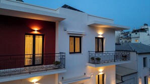 A modern two-story building with balconies, exterior lighting, and a red facade. - Angelinas Quarters - Kalamata Mediterranean Villas
 (Kalamata)