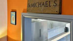 Una zona de cuina amb un rètol de fusta penjat sobre un frigorífic que diu "SIMICHAEL'S".