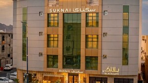 A modern building with a sign reading 'SUKNAI SIKKANI' and 'BLACKCAFE'. - Suknai Salah ElDin Serviced apartments (Ha'il)