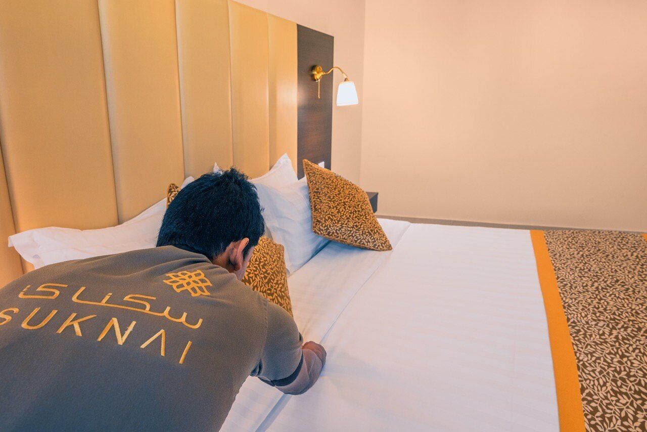 Une chambre d’hôtel avec un lit, des oreillers et une tête de lit.