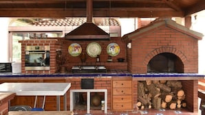 Una cocina con horno de ladrillo, horno empotrado y salpicadero azulejado.