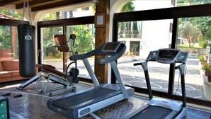 Un gimnasio con cintas de correr, una bicicleta estática y un saco de boxeo.