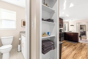 Een moderne badkamer met een toilet, een handdoekhouder en een plank met toiletartikelen.