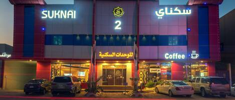 A building with signage for 'SUKNAI' and 'Coffee' on the ground floor, featuring a prominent number '2' above the entrance.