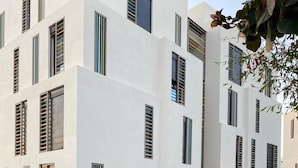 A modern building with multiple windows and a paved courtyard. - Ayla Vacation home 
 (Aqaba)