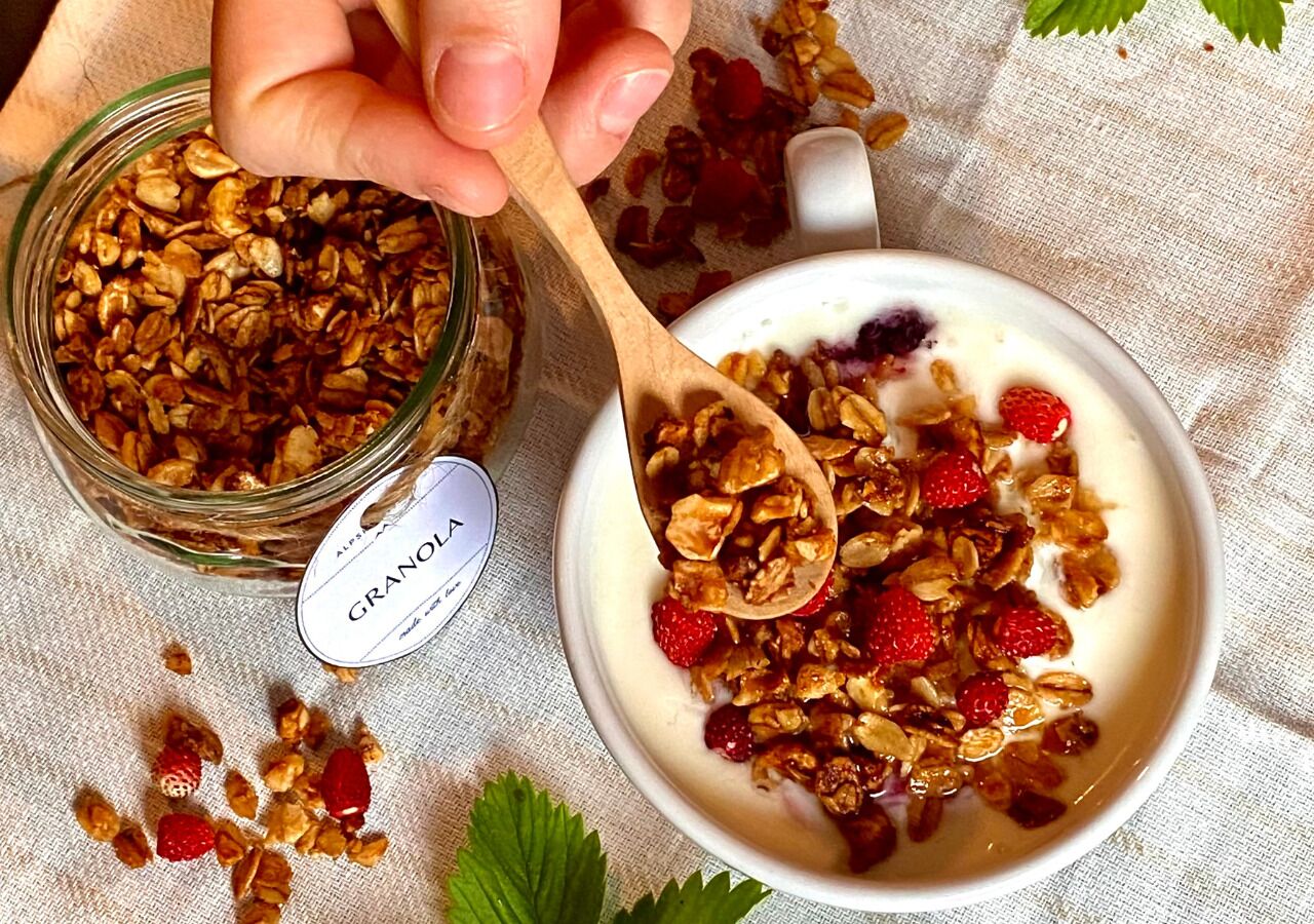 Un bol de granola aux fraises et un bocal de granola.
