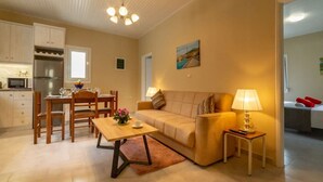 Un salon confortable avec un canapé, une table basse et un coin repas comprenant des chaises et une table.