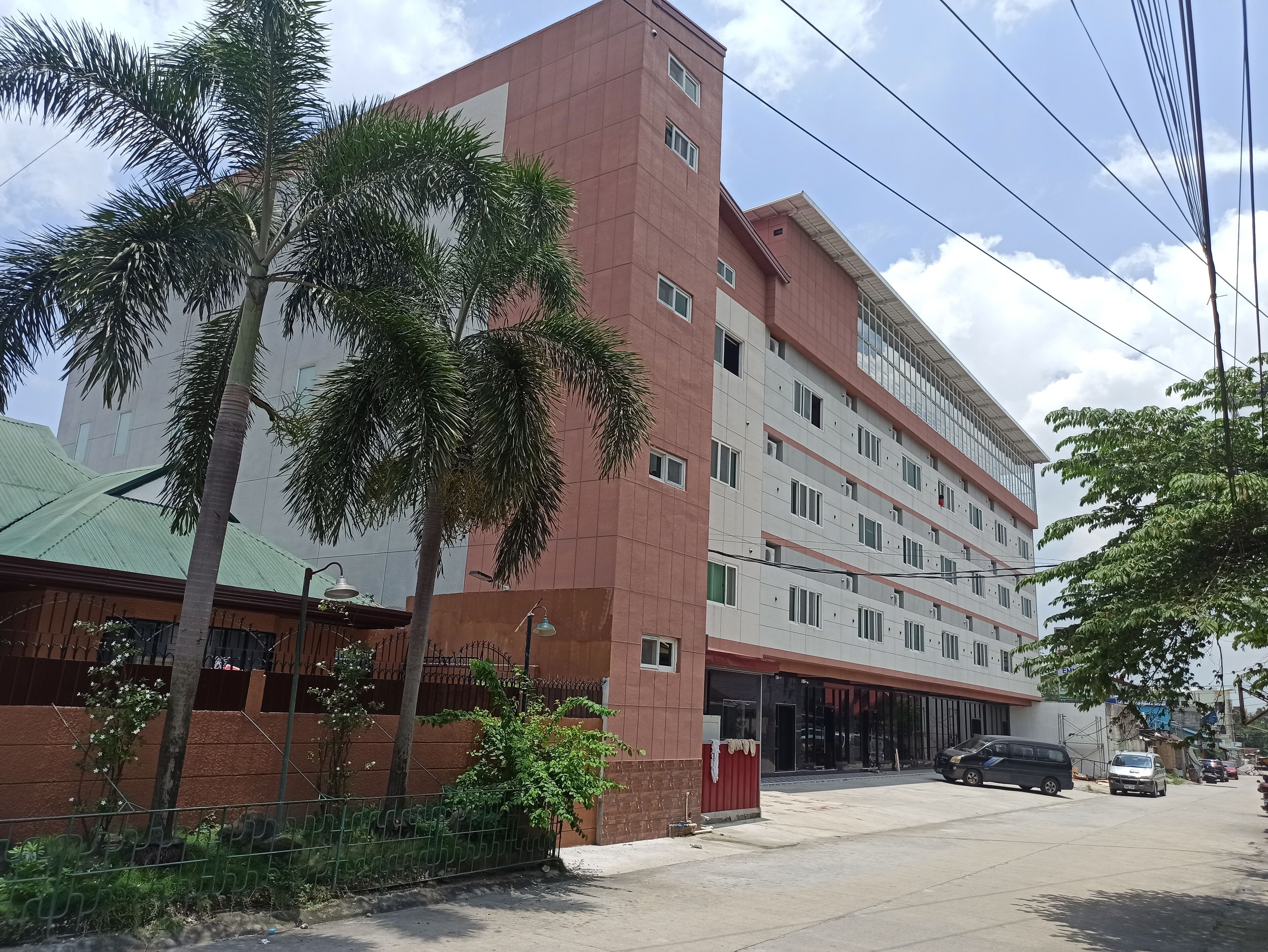 A multi-story building with a red and white facade, large windows, and a flat roof.