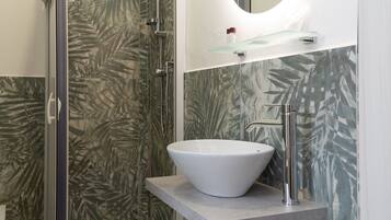 A bathroom with a shower, a sink, and a mirror.