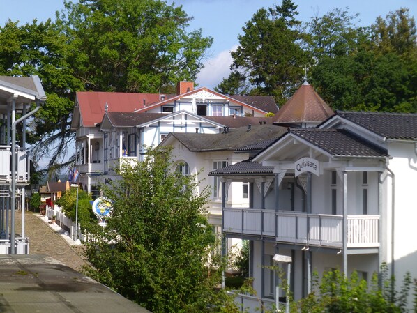 A row of traditional houses with distinct architectural styles, including a prominent white house with a balcony and a red-roofed house.