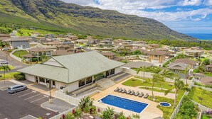 Zona residencial con casas, piscina y vistas a la montaña y al océano.