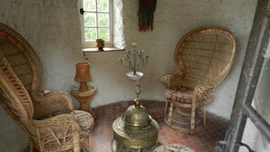 A traditional room with wicker furniture, a brass candelabra, and a patterned rug.