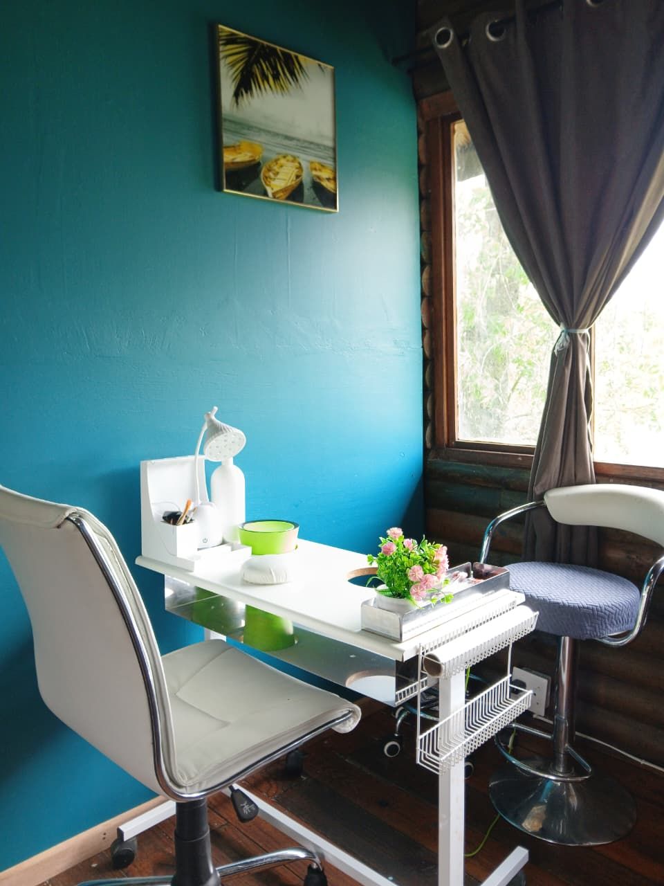 A small, private office with a desk, chair, and a window with curtains.