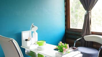 A small, private office with a desk, chair, and a window with curtains.