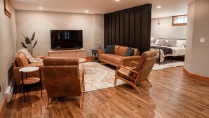 A modern living room with a sofa, armchairs, a coffee table, and a TV. - Modern, Sauna, Near Whiteface/Lake Placid, Dogs, Mountain Views (Wilmington)