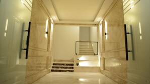 A modern interior with a marble staircase leading to a second floor. - White Palace Motel EG (New Cairo)
