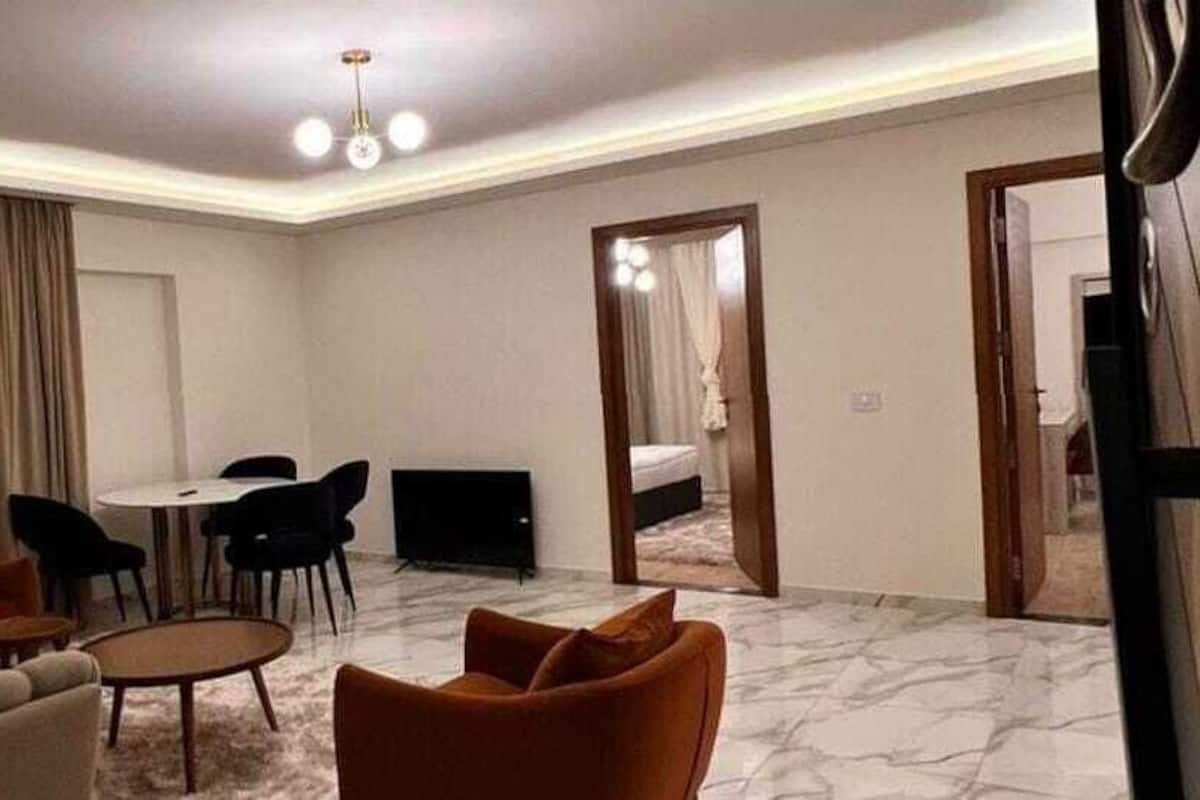 Una habitación de hotel con zona de estar, televisor y cama.