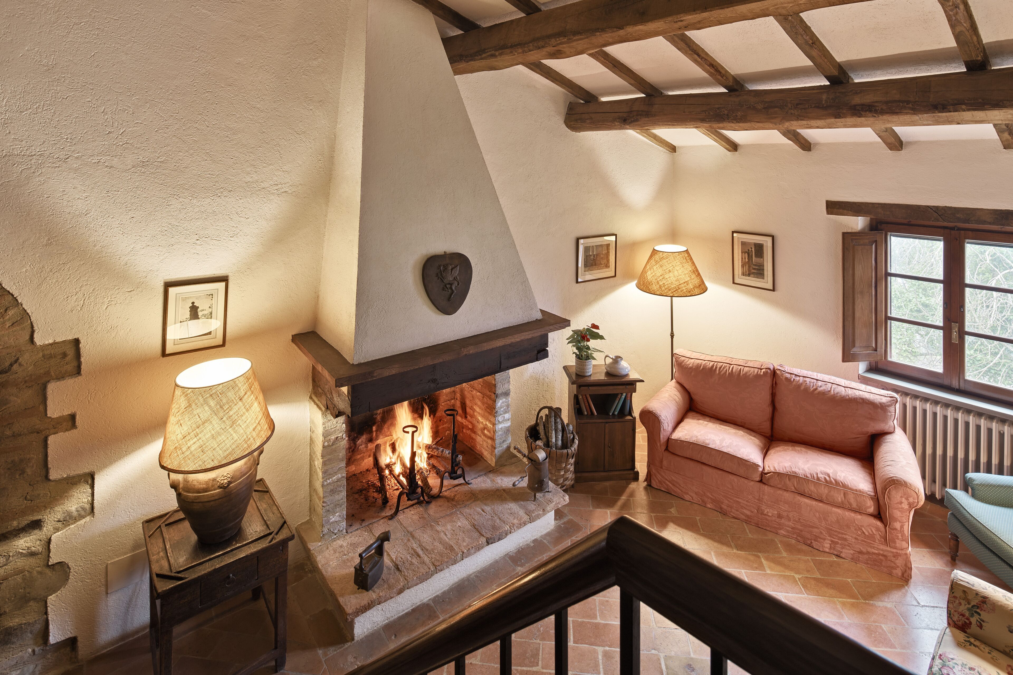 A cozy living room with a fireplace, a sofa, and a lamp.