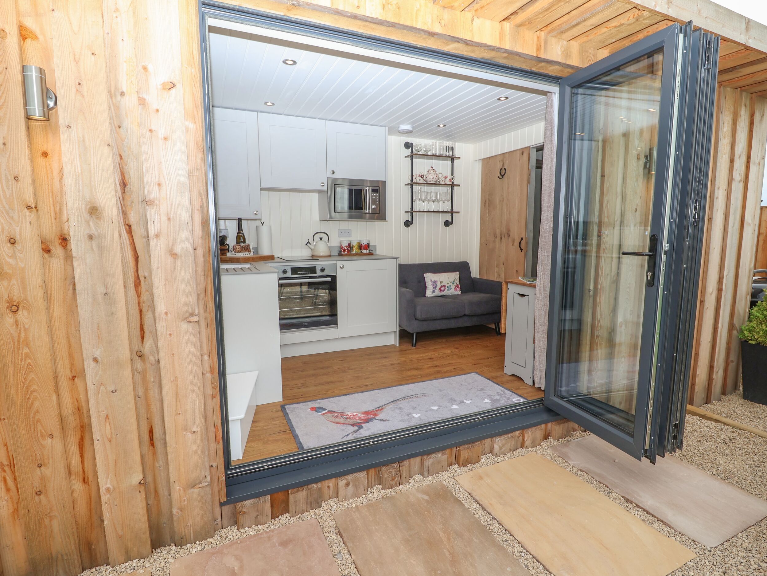 A modern kitchen with white cabinets, a microwave, and a built-in oven.