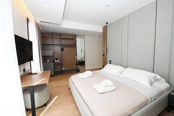 A modern hotel room with a large bed, a desk, a TV, and a wardrobe. - La Onda Hotel (Durrës)