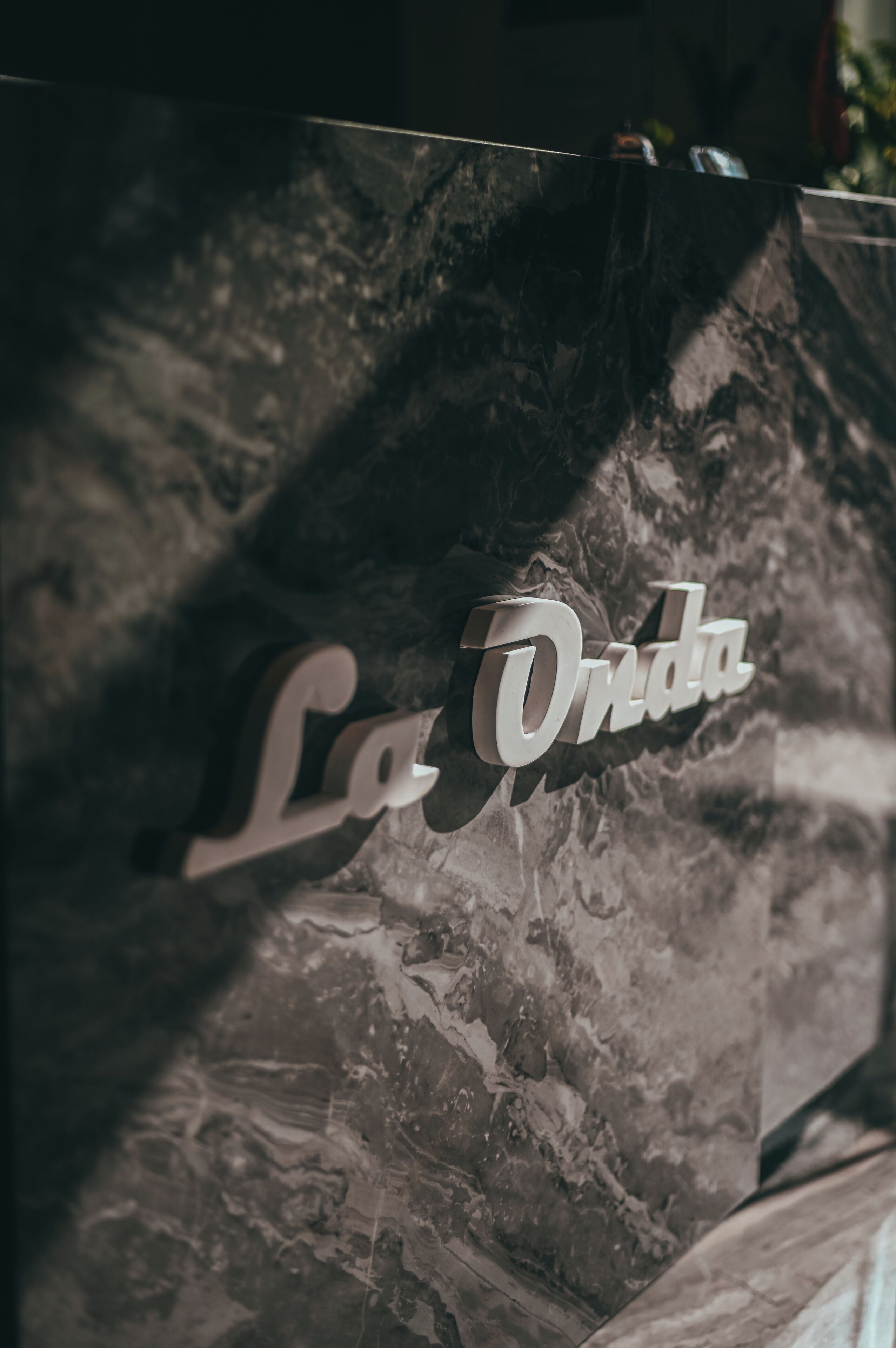 A marble wall with a sign that reads "La Onda."