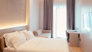 A hotel room with a large bed, a desk, and a chair. - La Onda Hotel (Durrës)
