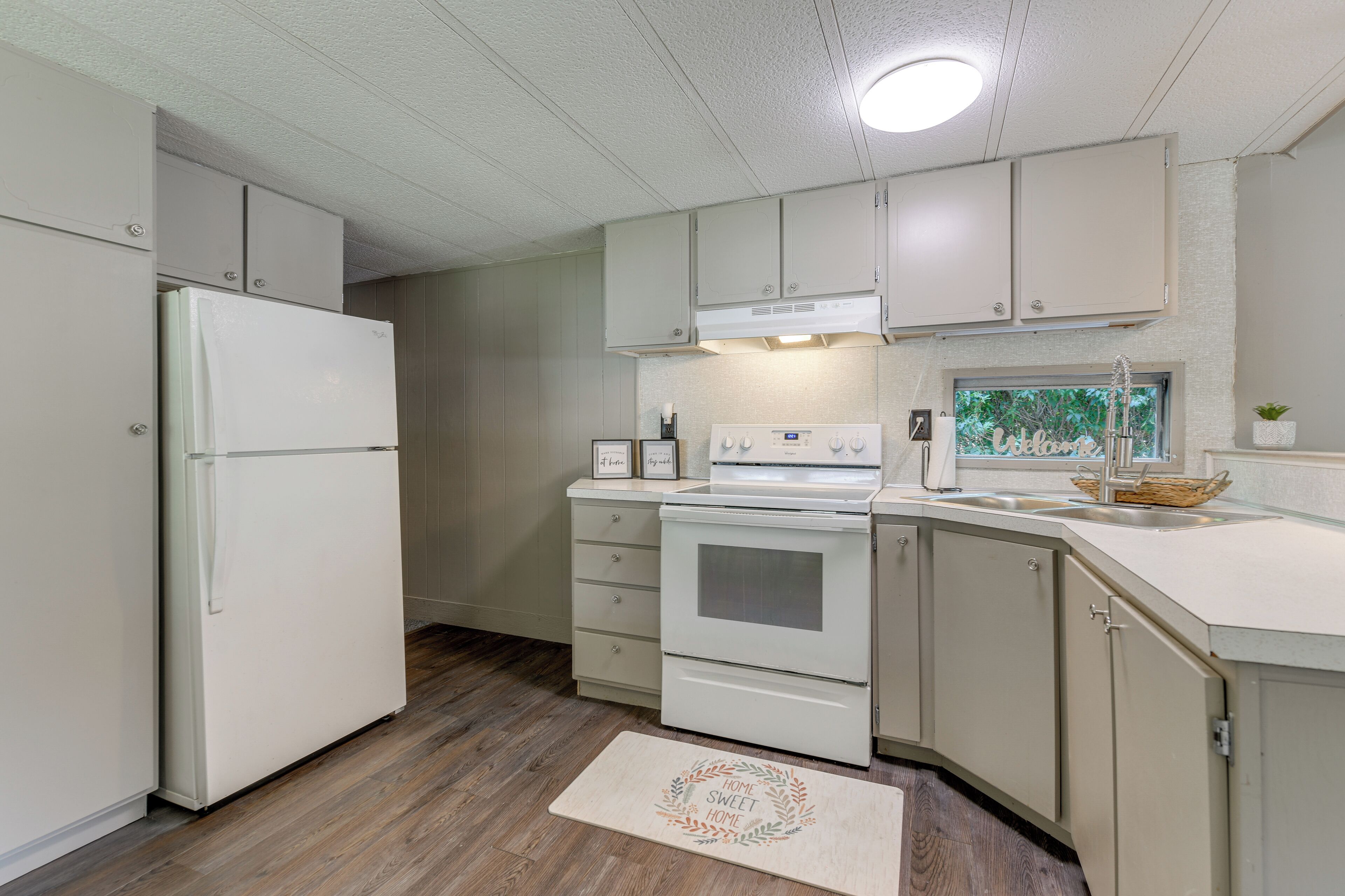 Una cocina equipada con refrigerador, estufa, horno y alacenas.