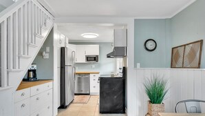 A compact kitchen with white cabinets, a microwave, a refrigerator, and a sink. - Adorable Cottage with Cottage porch, walk to water & town (Westbrook)