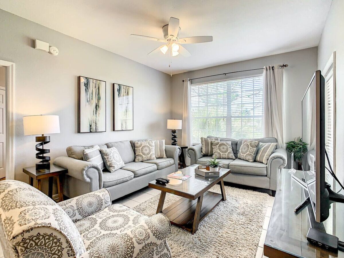 A modern living room with two sofas, a coffee table, and a TV.