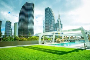 Área de piscina no terraço, com vista para edifícios modernos.