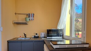 A compact kitchen with a microwave, kettle, and sink. - Calheta Countryside - Studio with Balcony (Ilha da Madeira)
