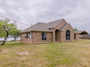 Set amidst a serene landscape, this charming single-story building features an arched doorway and a large window.