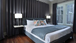 A modern hotel room with a large bed, two bedside tables, and a large window with curtains. - 3BR Old Mansion in Montrose! Downtown, Medical Center (Houston)
