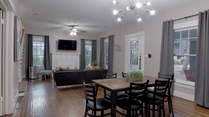 A modern kitchen with a dining area, wooden flooring, and a ceiling fan. - 3BR Old Mansion in Montrose! Downtown, Medical Center (Houston)