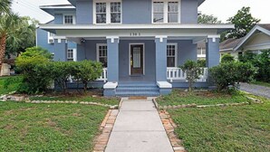 A two-story house with a front porch, a number plate reading "1301", and a small garden area with a pathway leading to the entrance. - 3BR Old Mansion in Montrose! Downtown, Medical Center (Houston)
