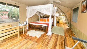 Una camera da letto in stile tenda con pavimento in legno, un letto a baldacchino, un tavolino con un bollitore e una panca.