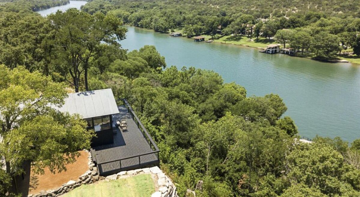 Une propriété située au bord du lac, dotée d’une grande terrasse et offrant une vue sur le lac.