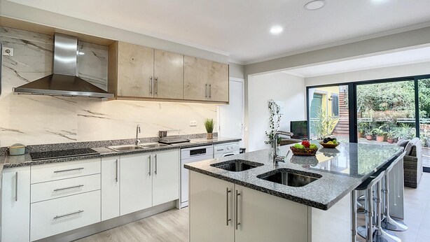 A modern kitchen with white cabinets, granite countertops, and stainless steel appliances. - Solarium Villa by Atlantic Holiday (Machico)