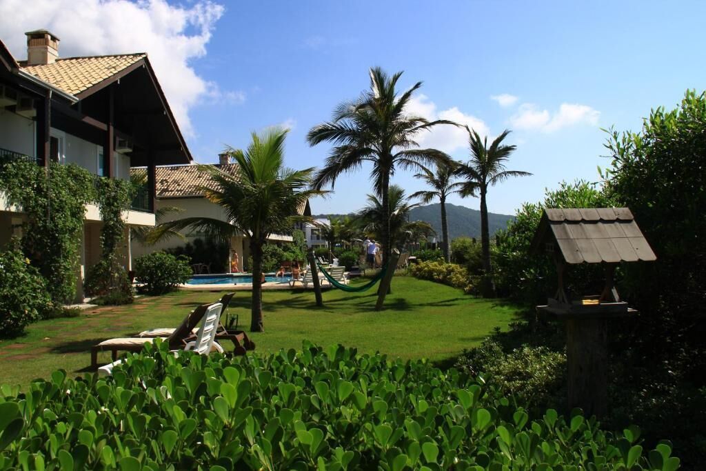 Ein Resort mit Pool, Palmen und einer Laube.