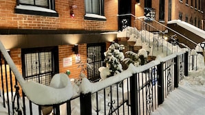 Una scala coperta di neve con un rilevatore di fumo e un cartello per i Vigili del Fuoco Siamese Connection.