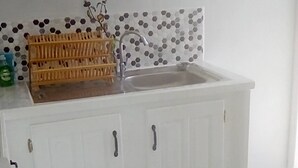 Cuina amb armaris blancs, respatller de rajola i un rentamans.